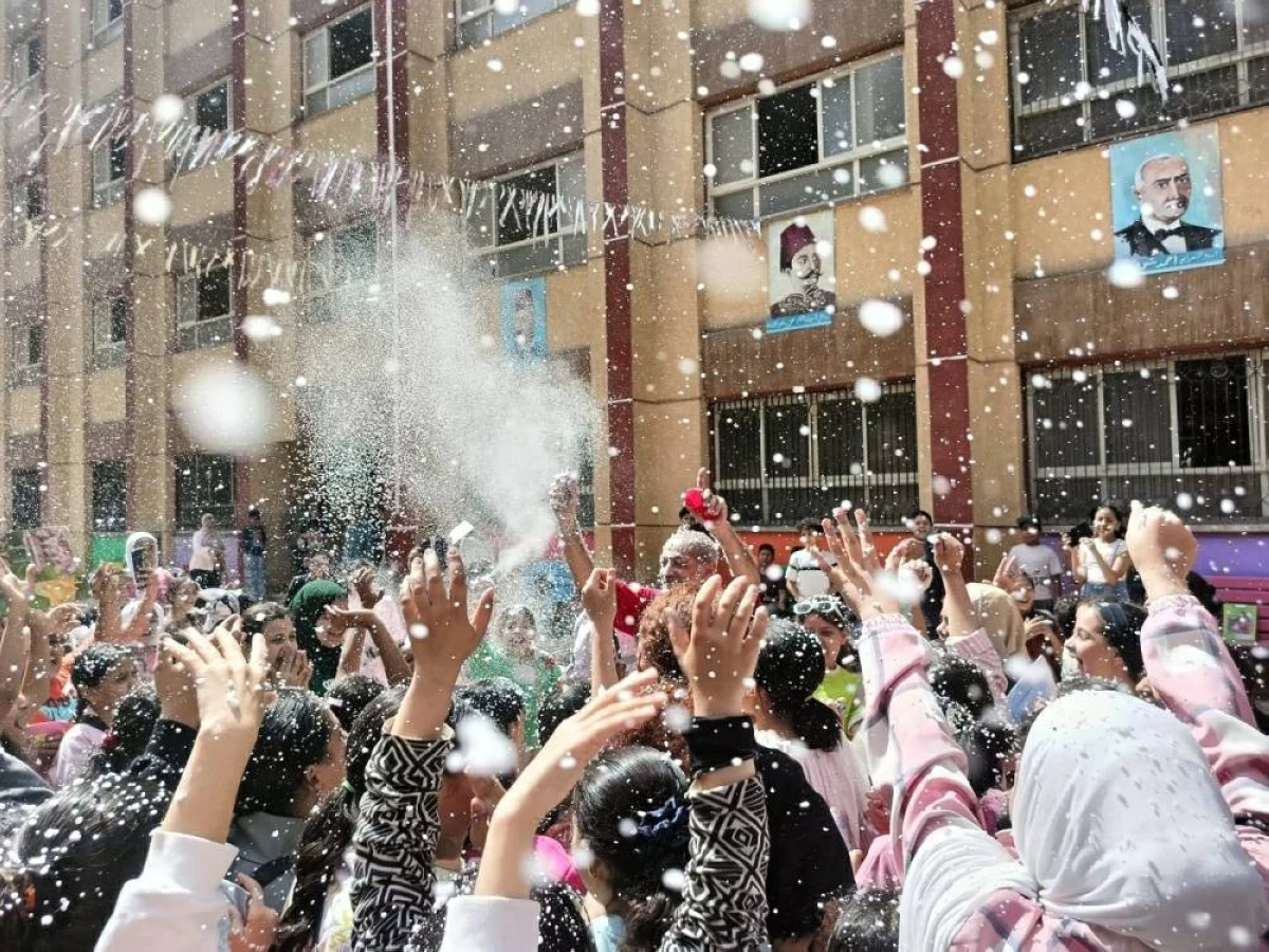 احتفال مدير مدرسة بالجيزة بخاخ الثلج مع التلاميذ